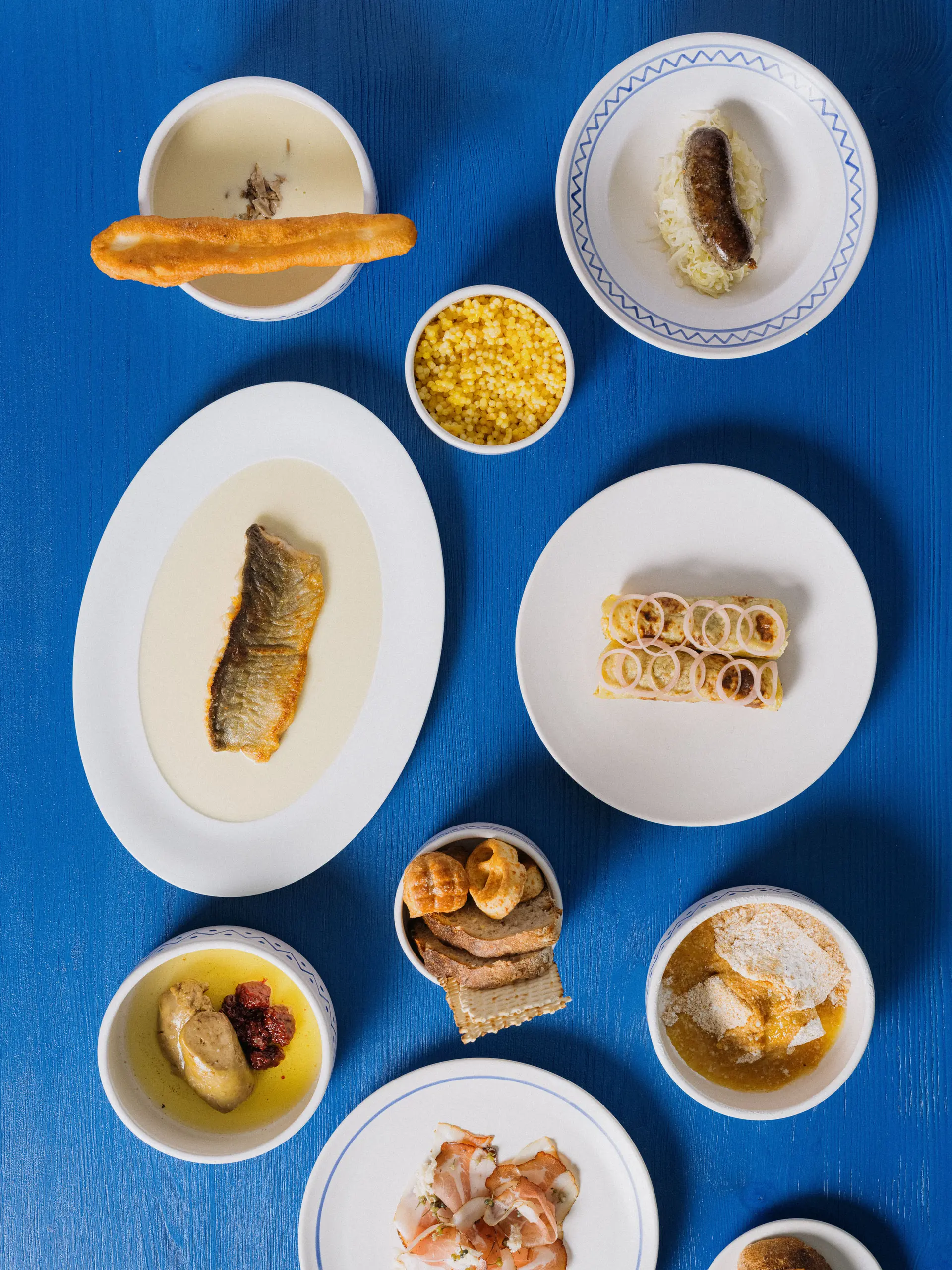 Nabídka jídel v restauraci Skô, pohled shora na talíře s tradičními pokrmy.